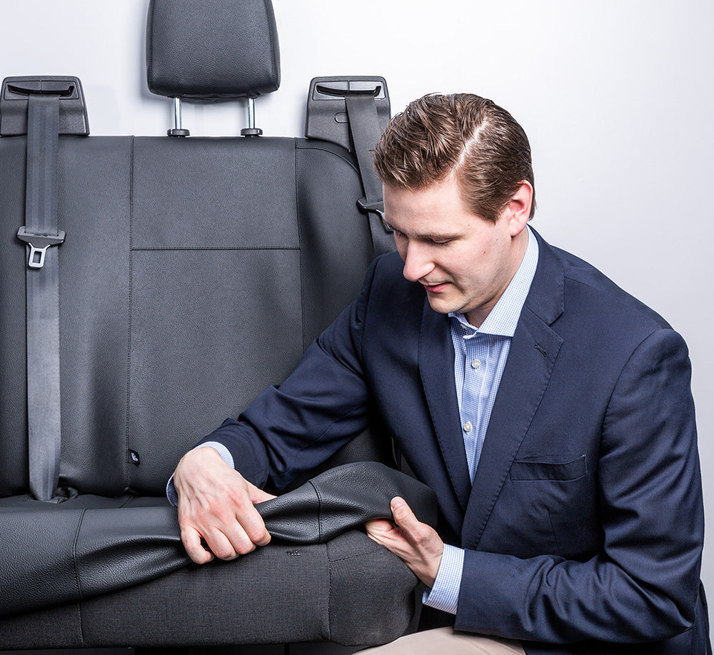 Ein Mann bezieht gerade die Autositze mit einem Sitzbezug von ACTIVline